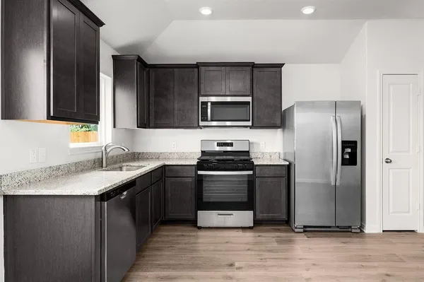 a kitchen with a sink stove and refrigerator