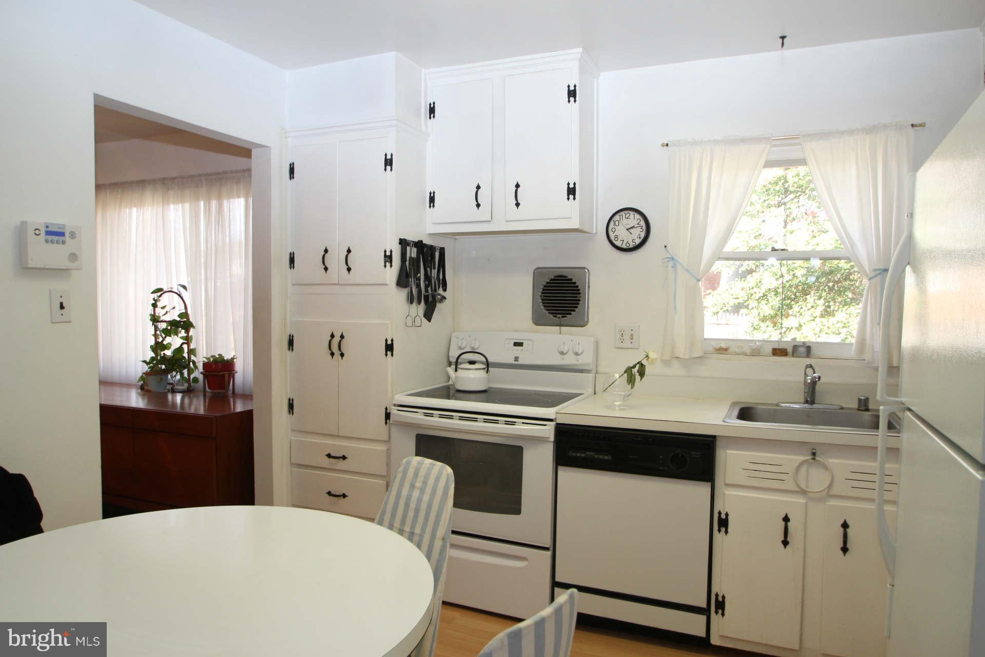 3811 Kayson Street Silver Spring, MD 20906 - Photo 7 of 30 a kitchen with stainless steel appliances a sink a stove and white cabinets
