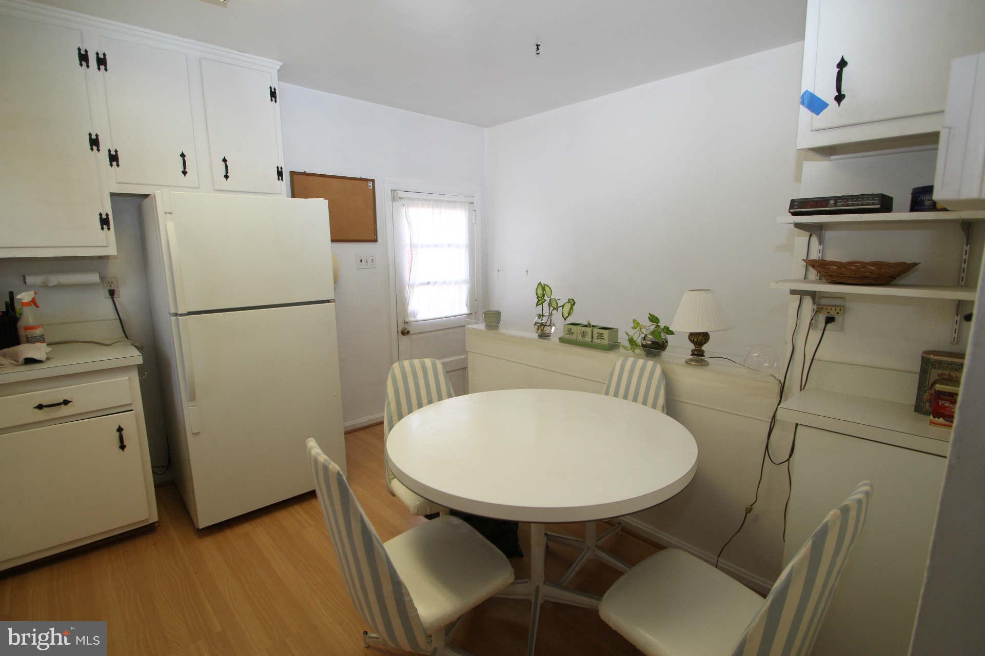 3811 Kayson Street Silver Spring, MD 20906 - Photo 8 of 30 a white kitchen with a sink a refrigerator and a stove