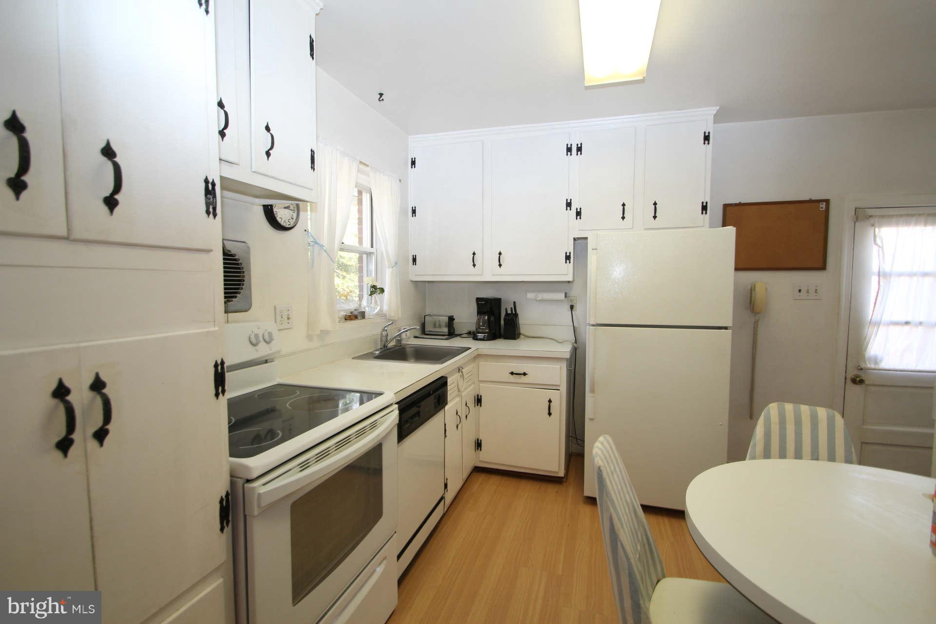 3811 Kayson Street Silver Spring, MD 20906 - Photo 9 of 30 a kitchen with white cabinets and stainless steel appliances