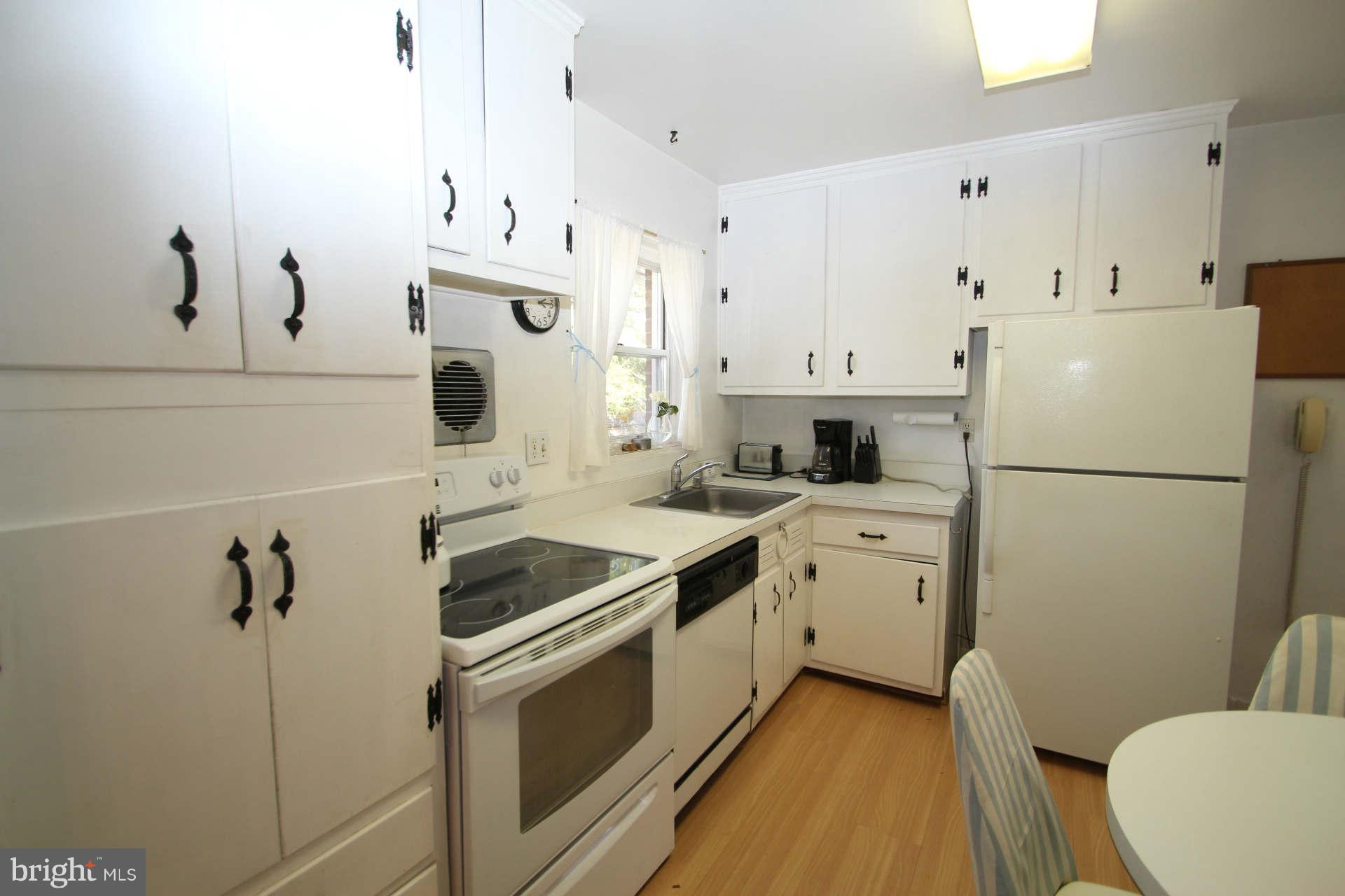 3811 Kayson Street Silver Spring, MD 20906 - Photo 10 of 30 a kitchen with white cabinets and white appliances