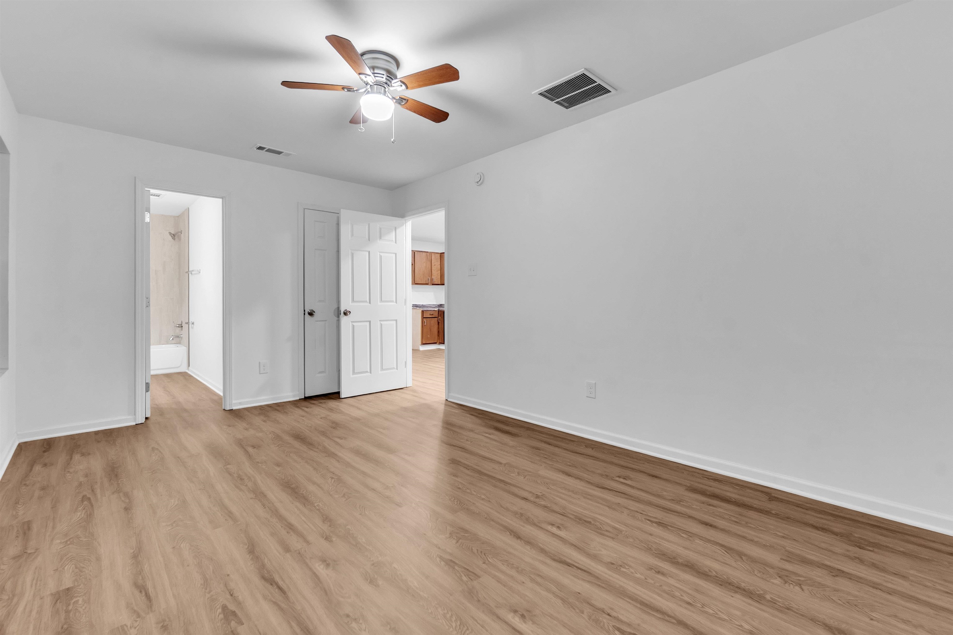 3021 Chelsea Avenue Memphis, TN 38108 - Photo 5 of 17 Unfurnished bedroom with a ceiling fan, light wood-style flooring, and ensuite bathroom