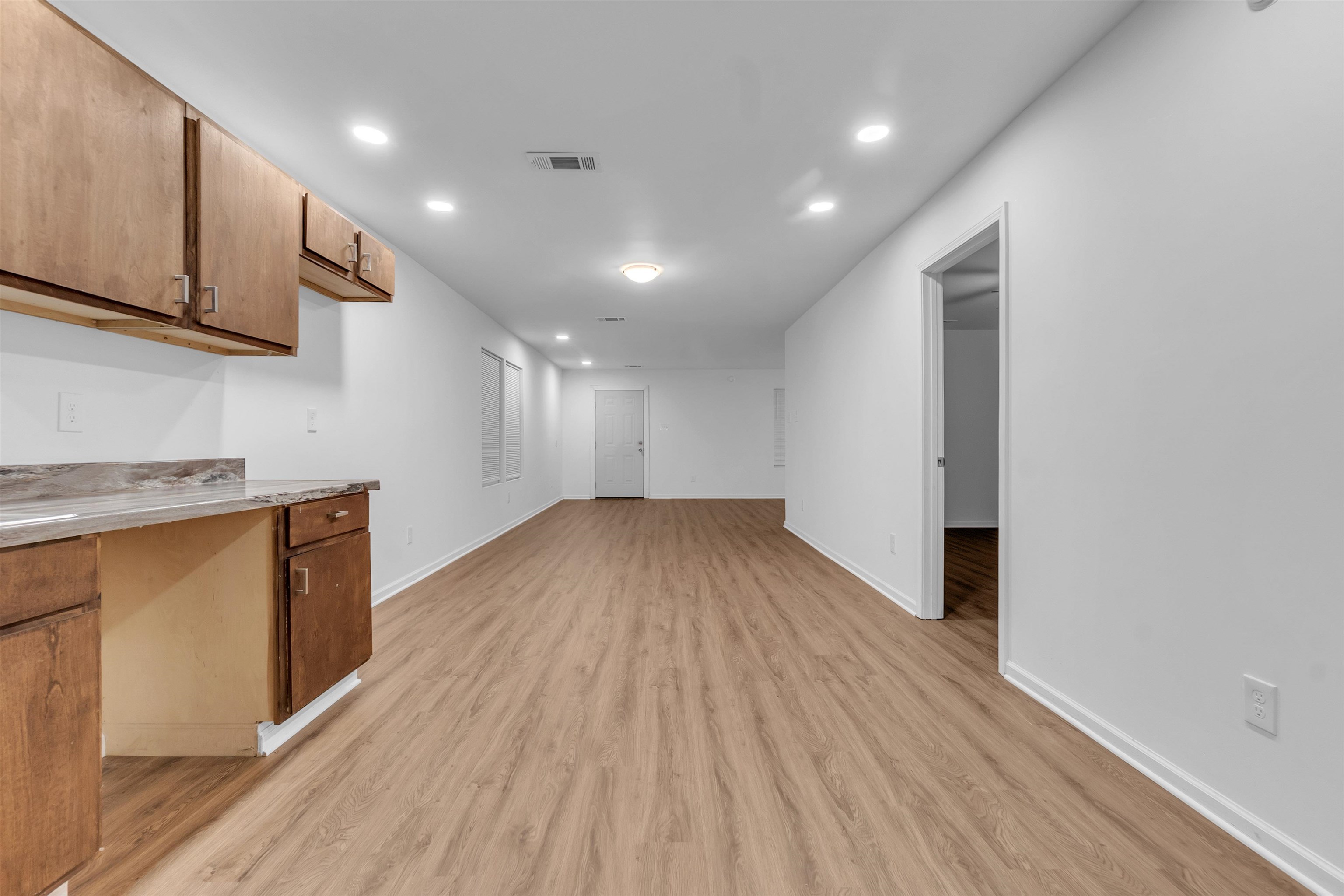 3021 Chelsea Avenue Memphis, TN 38108 - Photo 8 of 17 Bar with brown cabinetry, recessed lighting, and light wood-type flooring