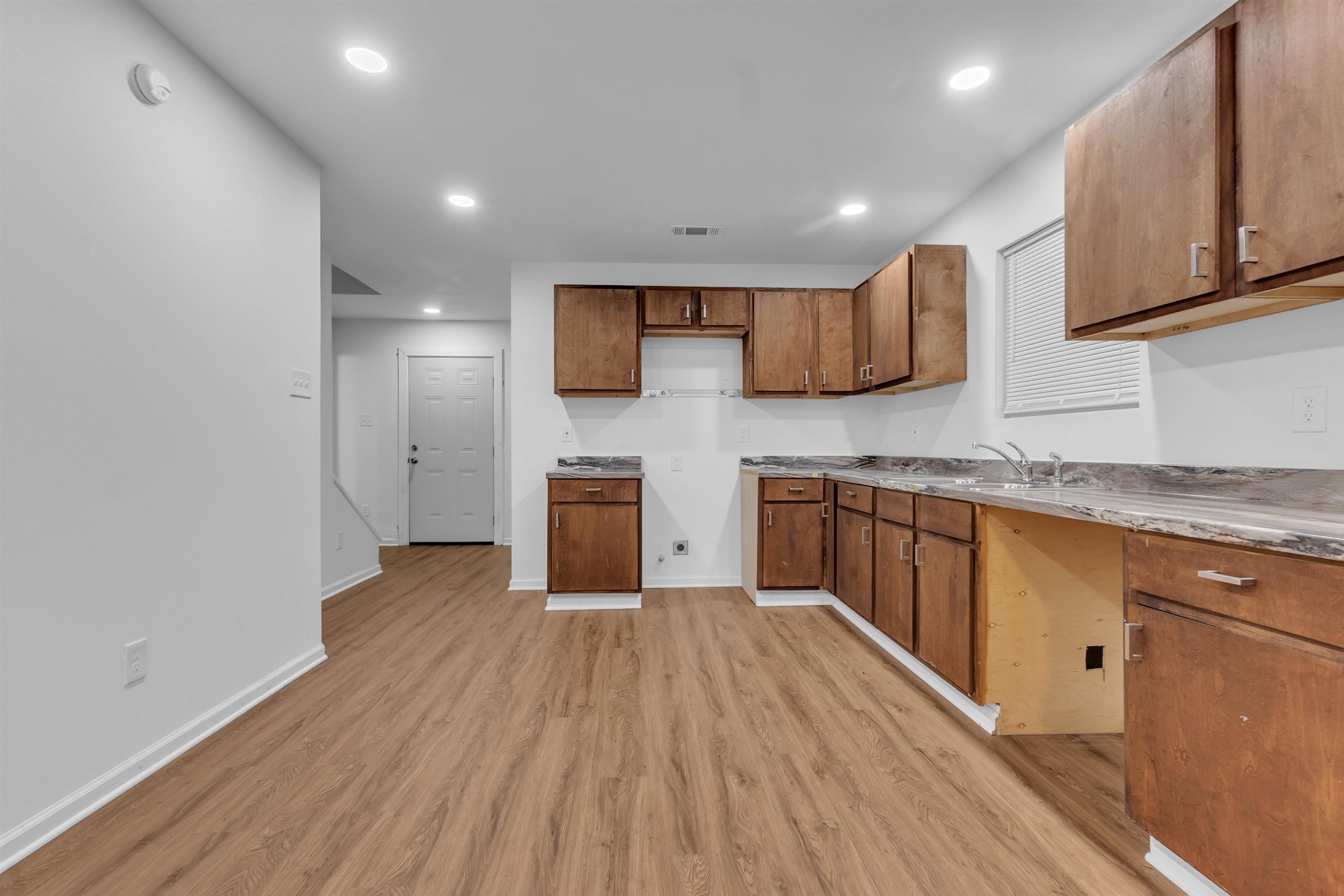 3021 Chelsea Avenue Memphis, TN 38108 - Photo 9 of 17 Kitchen with brown cabinets, recessed lighting, light countertops, and light wood-style floors