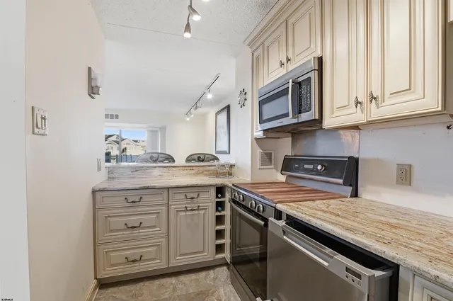 a kitchen with stainless steel appliances granite countertop a sink and a stove