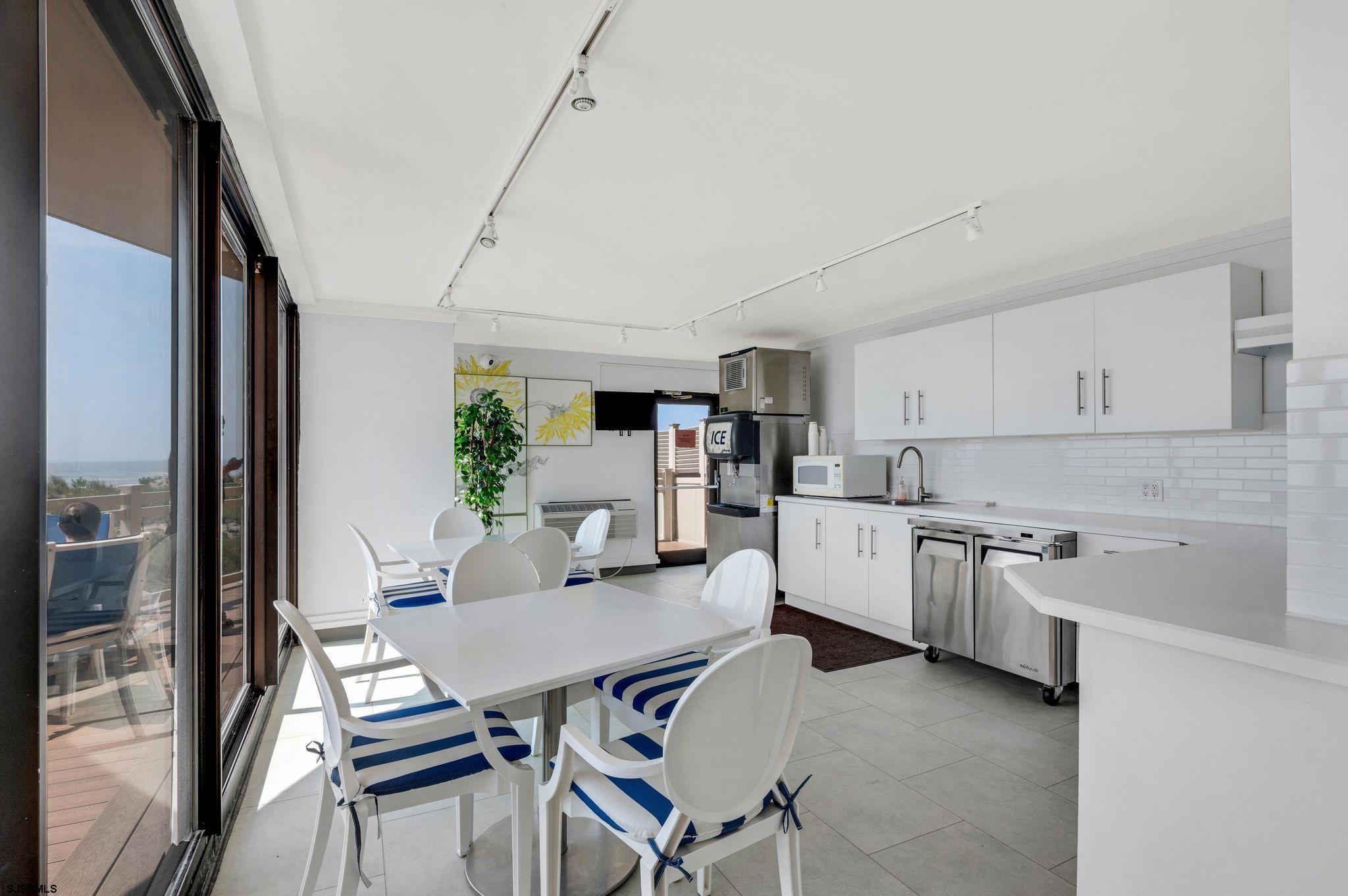 2700 Atlantic Avenue, Unit 209 Longport, NJ 08403 - Photo 27 of 31 a kitchen with cabinets table and chairs
