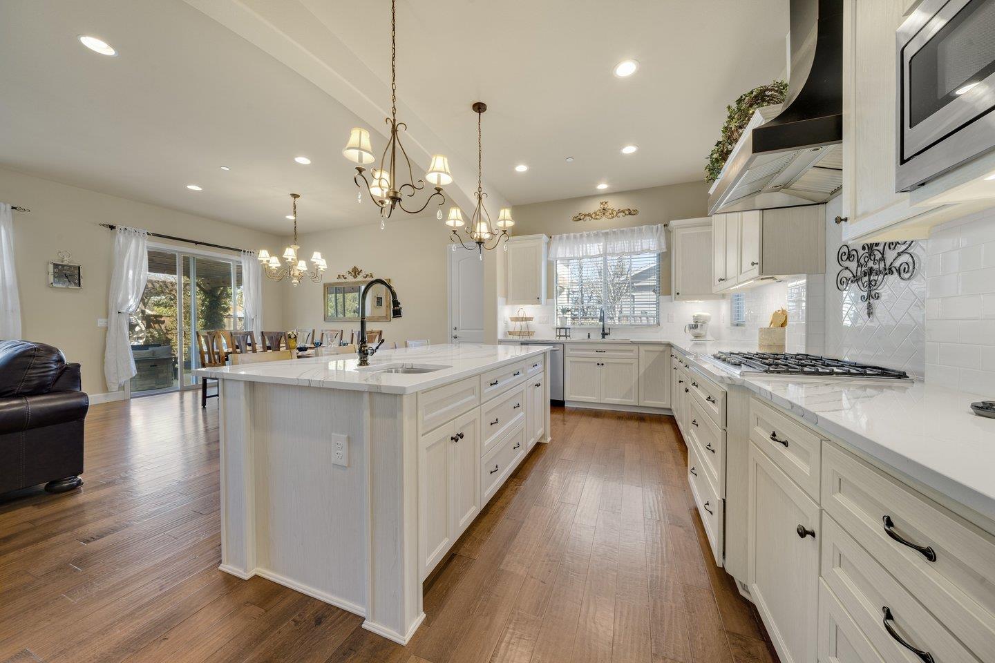 3943 Vía Cristobal Campbell, CA 95008 - Photo 16 of 59 a large white kitchen with lots of counter space wooden floor and stainless steel appliances