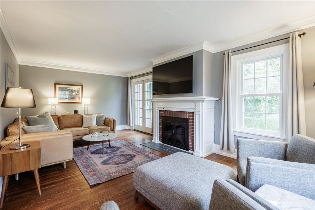 387 Kilbourn Road Rochester, NY 14618 - Photo 15 of 42 Rich hardwood flooring anchors the living room centered around a classic brick fireplace.