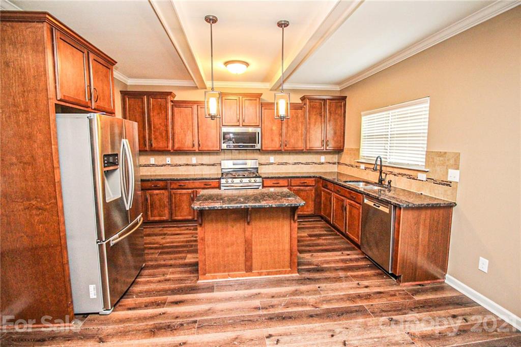 7042 Meyer Road Fort Mill, SC 29715 - Photo 7 of 18 a kitchen with stainless steel appliances granite countertop a refrigerator a sink dishwasher a stove and white countertops with wooden floor