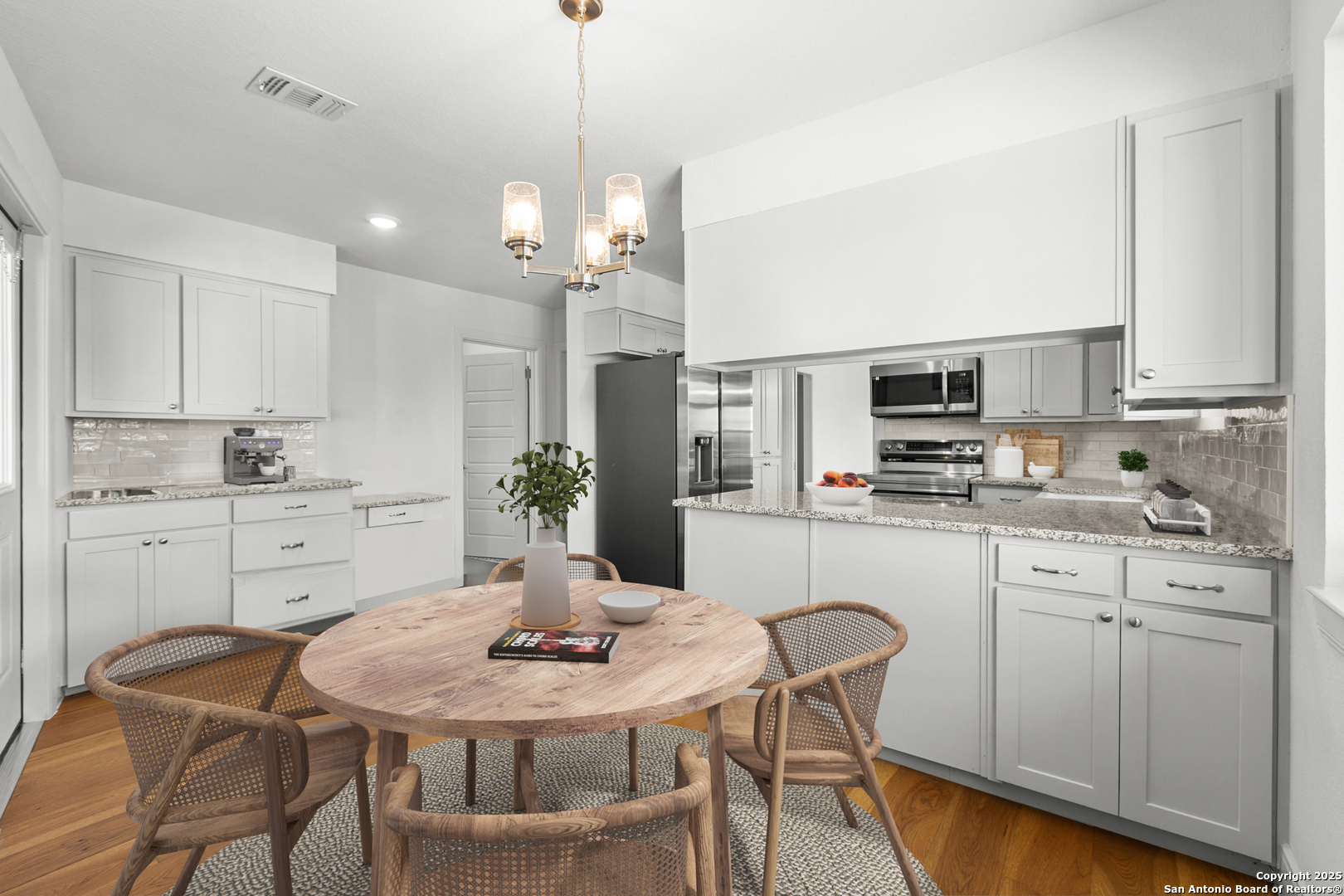 935 Spring Branch Road Spring Branch, TX 78070 - Photo 13 of 48 a kitchen with stainless steel appliances kitchen island granite countertop a dining table chairs and white cabinets