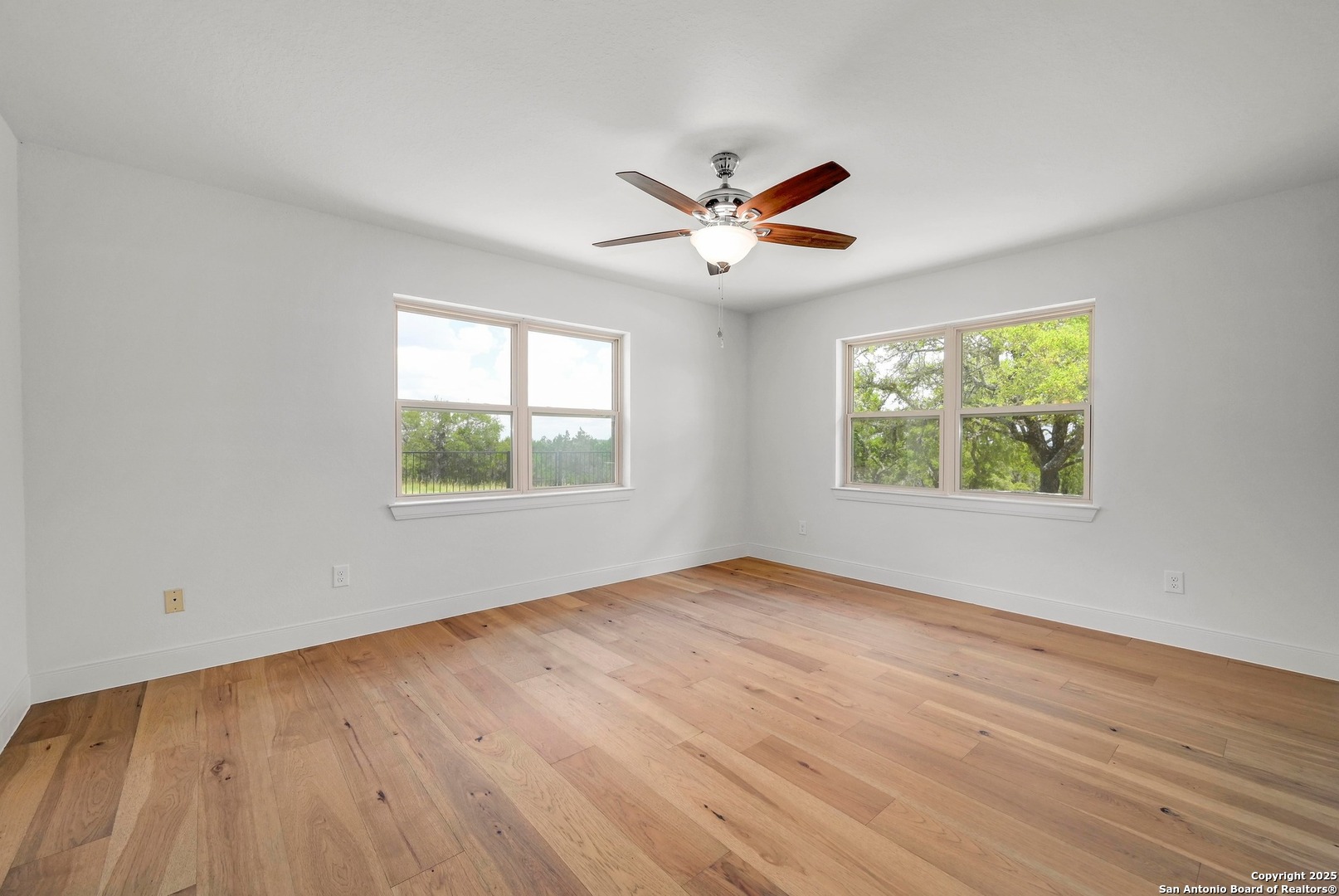 935 Spring Branch Road Spring Branch, TX 78070 - Photo 14 of 48 a view of an empty room with wooden floor and a window