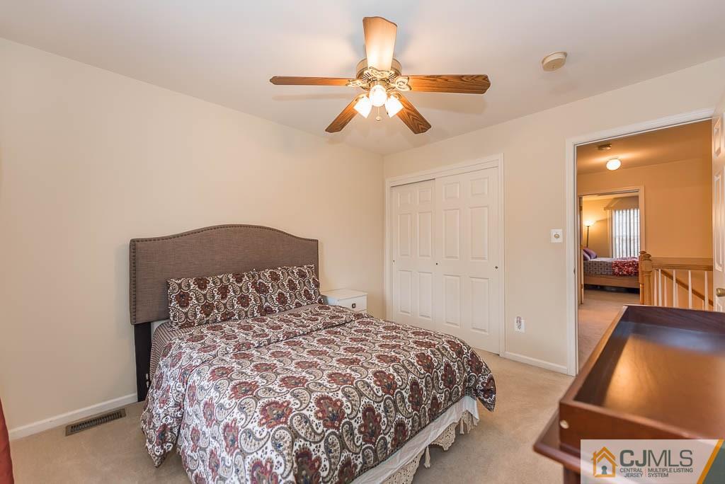 6 Alexandra Way Clinton, NJ 08809 - Photo 22 of 25 a bedroom with a bed and a chandelier