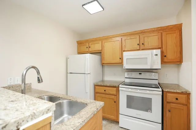 a kitchen with a sink a stove and cabinets