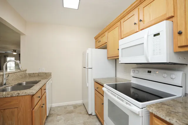 a kitchen with granite countertop cabinets washer and dryer