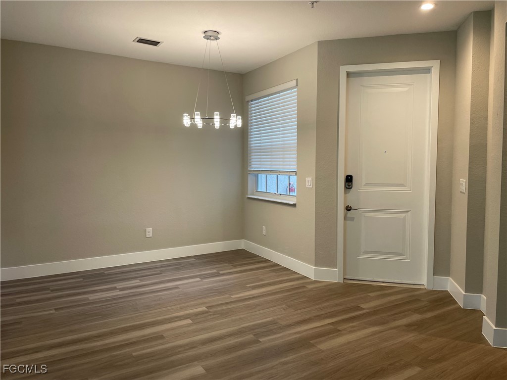 7081 Venice Way, Unit 1804 Naples, FL 34119 - Photo 5 of 12 a view of an empty room with wooden floor