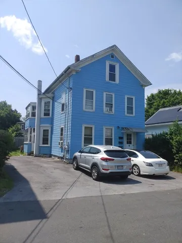 a front view of a house with parking space and a car parked in front of it