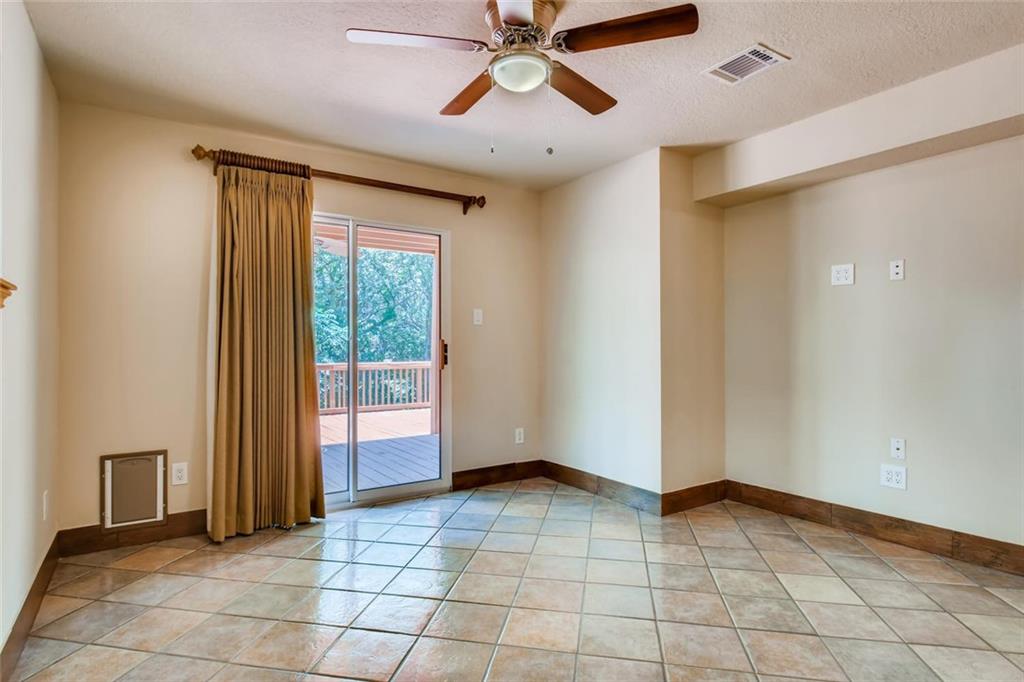 1600 Whitney Way Austin, TX 78741 - Photo 19 of 26 Unfurnished room with ceiling fan, a textured ceiling, and light tile patterned floors