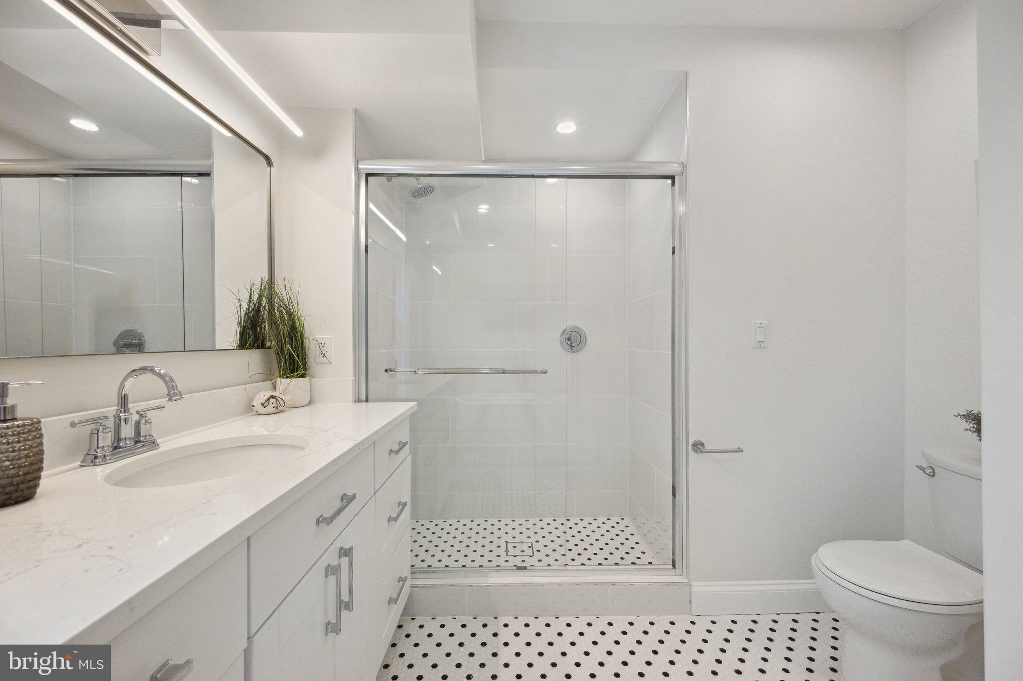 2444 Tunlaw Road Northwest Washington, DC 20007 - Photo 21 of 38 a bathroom with a granite countertop sink toilet and shower