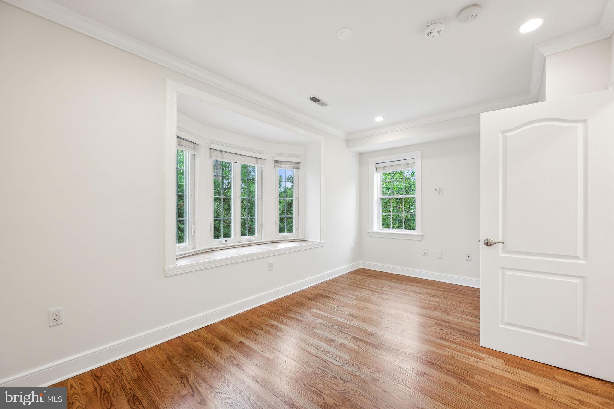 2444 Tunlaw Road Northwest Washington, DC 20007 - Photo 23 of 38 an empty room with wooden floor and windows