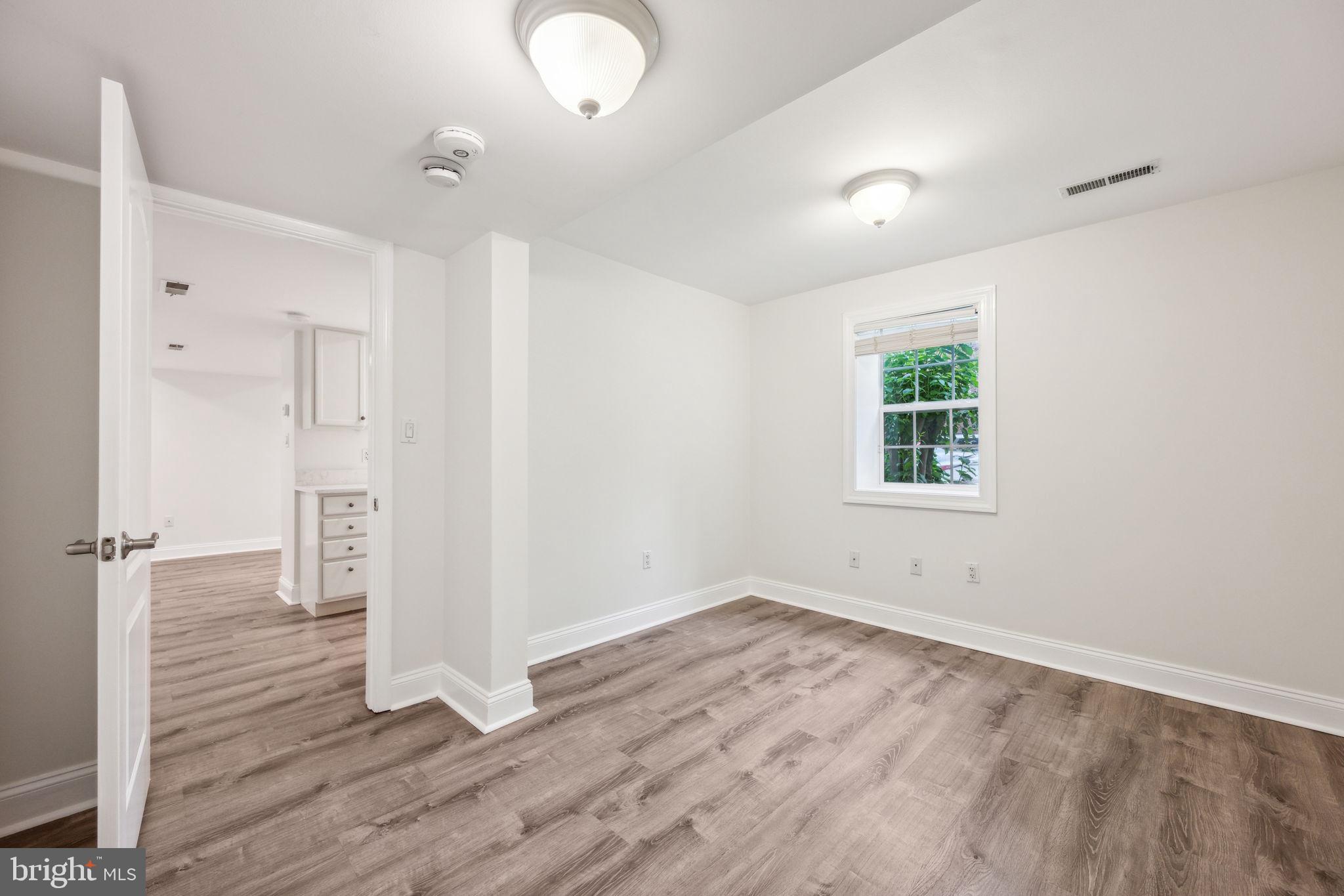 2444 Tunlaw Road Northwest Washington, DC 20007 - Photo 34 of 38 wooden floor in an empty room with a window