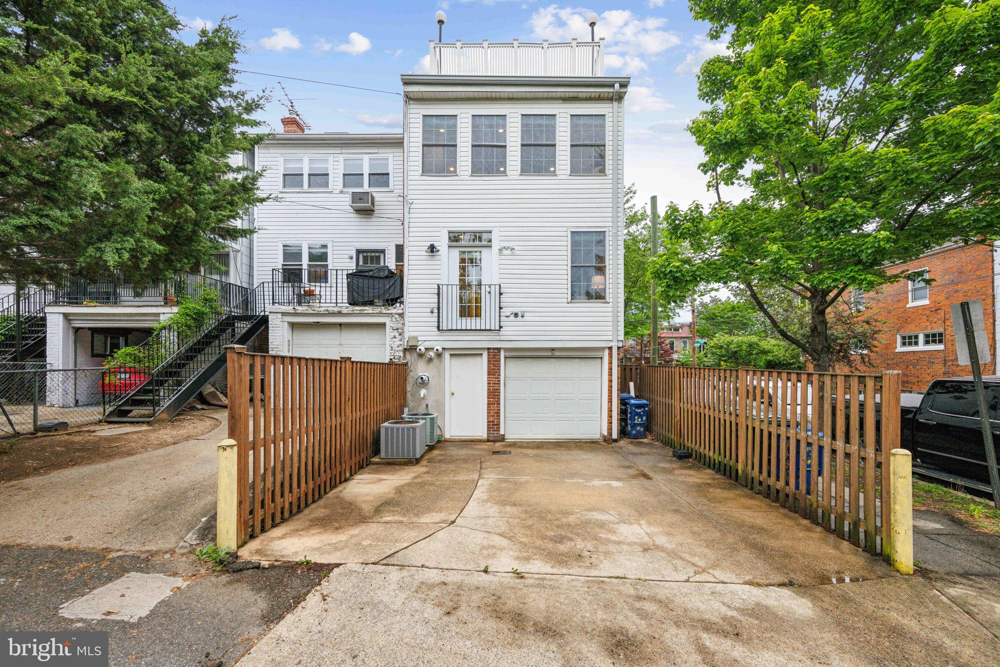 2444 Tunlaw Road Northwest Washington, DC 20007 - Photo 37 of 38 a view of a white building among the street with palm trees