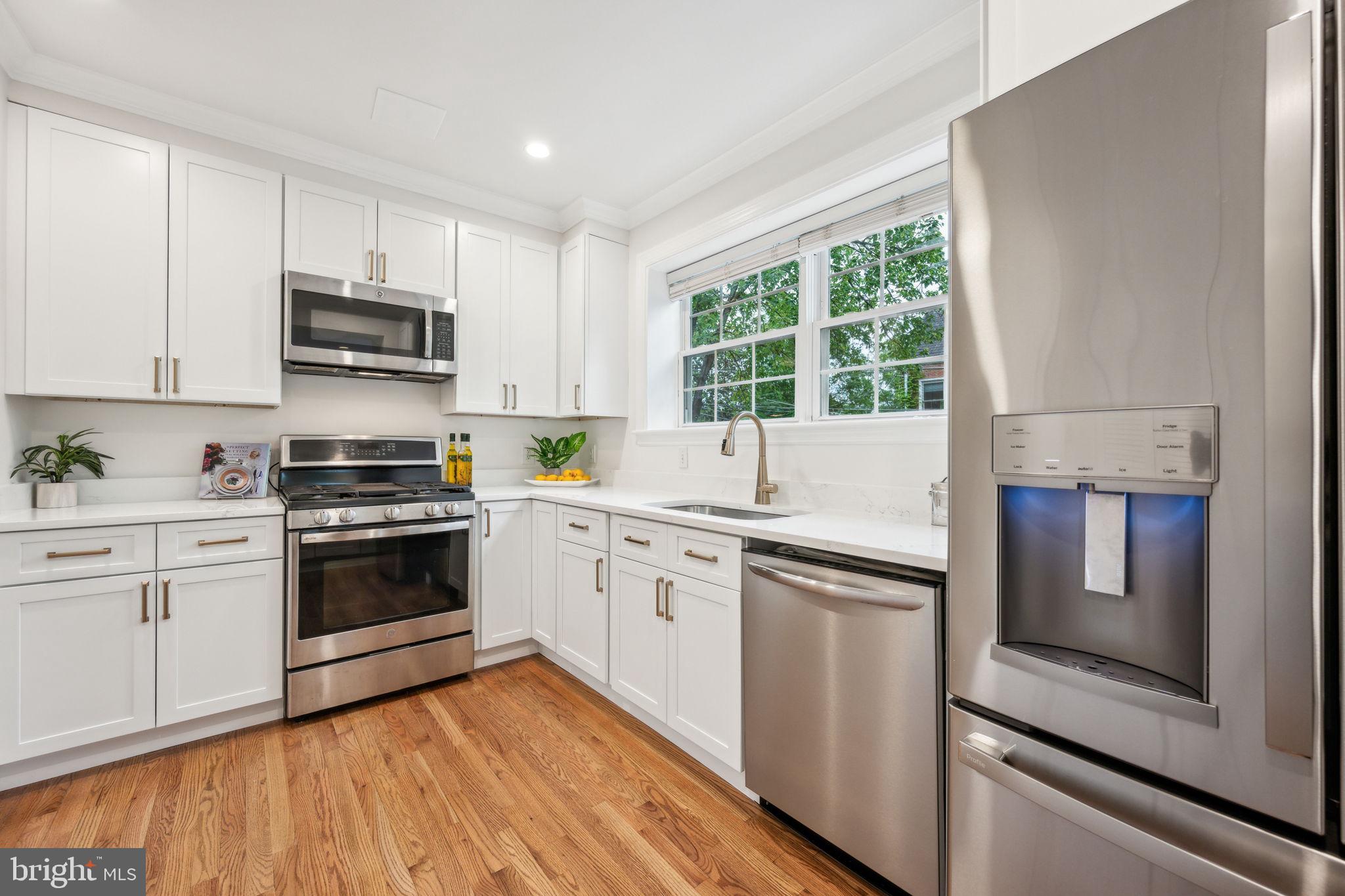 2444 Tunlaw Road Northwest Washington, DC 20007 - Photo 7 of 38 a kitchen with granite countertop white cabinets and white appliances