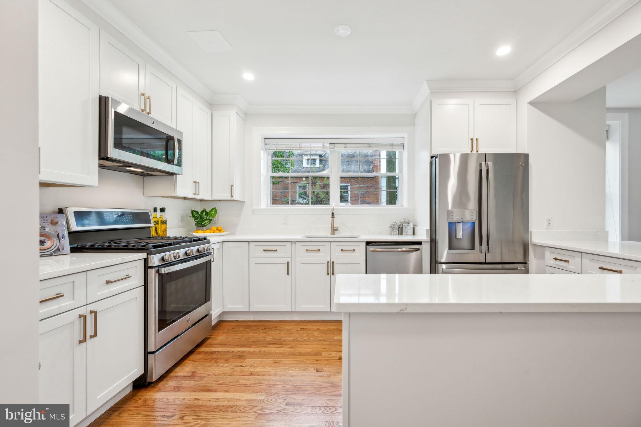 2444 Tunlaw Road Northwest Washington, DC 20007 - Photo 8 of 38 a kitchen with stainless steel appliances granite countertop a stove a sink and a microwave
