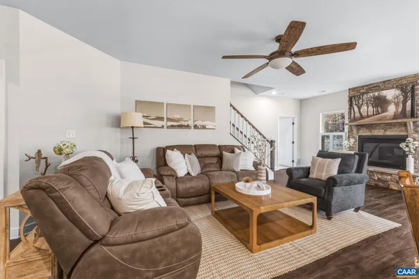 a living room with furniture kitchen view and a chandelier