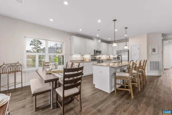 a dining room filled chandelier and wooden floor