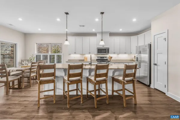 a large kitchen with kitchen island a large counter top space appliances and a center island