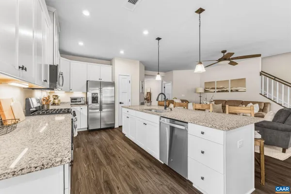 a kitchen with granite countertop white cabinets and white appliances