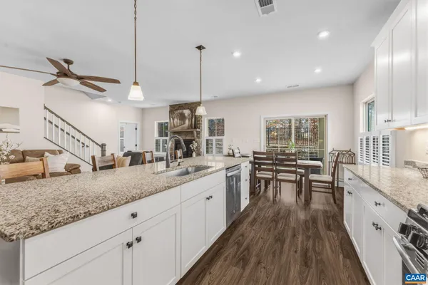 a kitchen with kitchen island granite countertop wooden floors and white appliances