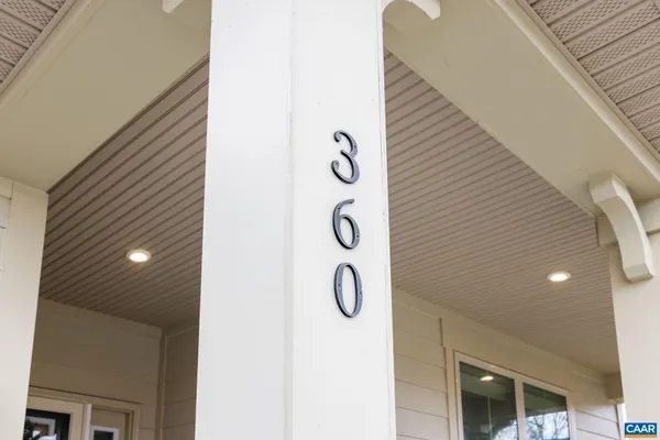 a view of a hallway to a livingroom with wooden floor and furniture