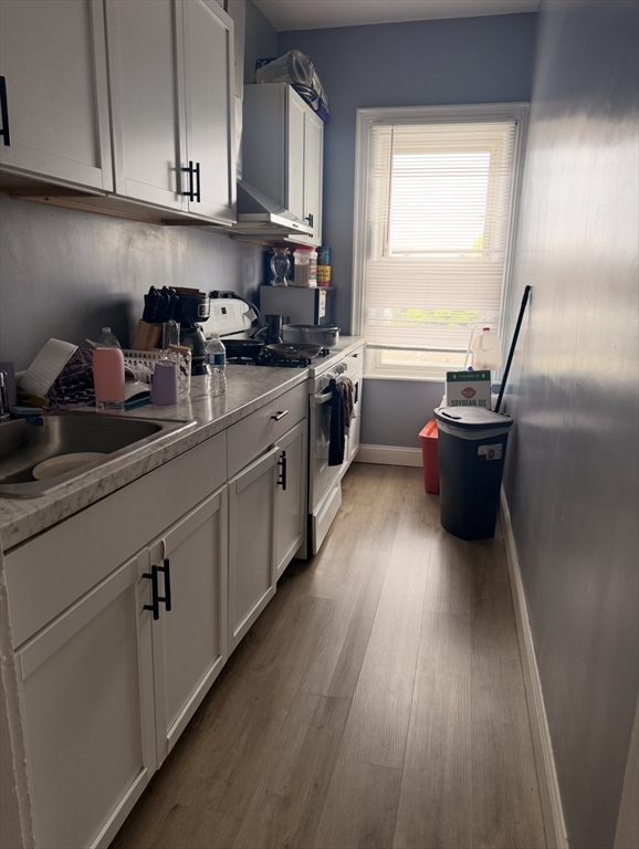 40 Park Street Fall River, MA 02721 - Photo 3 of 4 a kitchen with a sink and wooden floor