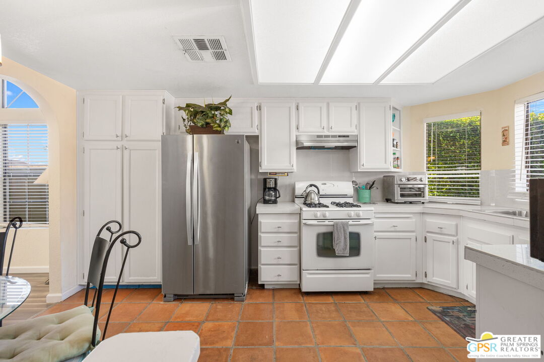 45688 Sutter Creek Road Indio, CA 92201 - Photo 13 of 51 a kitchen with stainless steel appliances a stove a refrigerator a sink a dining table and chairs