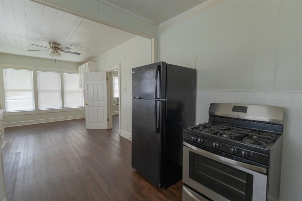 2913 Homan Avenue, Unit 2913 Waco, TX 76707 - Photo 15 of 16 Stainless steel range with a black refrigerator, wood-finish flooring, and a ceiling fan