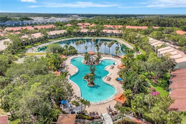 an aerial view of a house with a swimming pool a yard and lake view