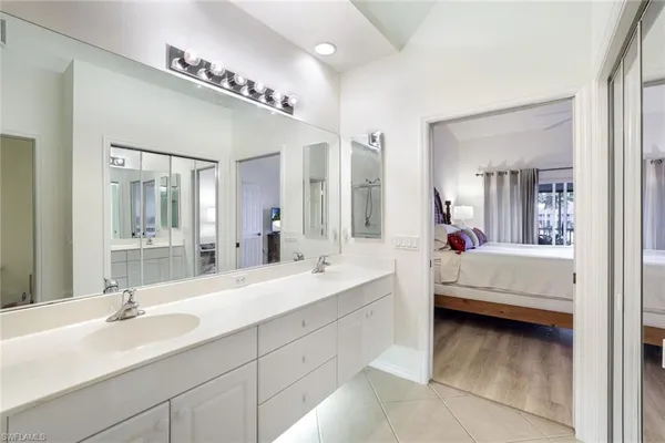 a en suite bathroom with a double vanity sink mirror and bathtub