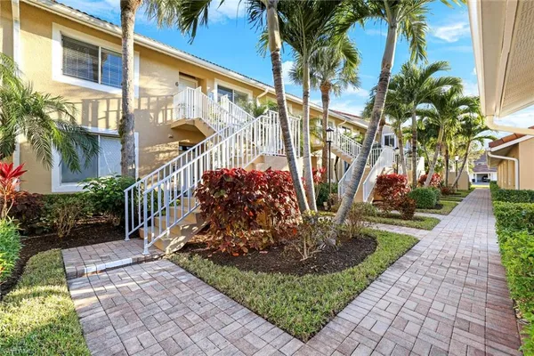 a view of a house with a yard and potted plants