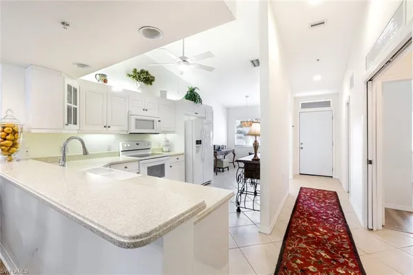a kitchen with white cabinets and sink