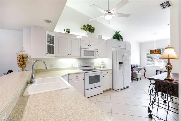 a kitchen with stainless steel appliances a stove a sink cabinets and a dining table