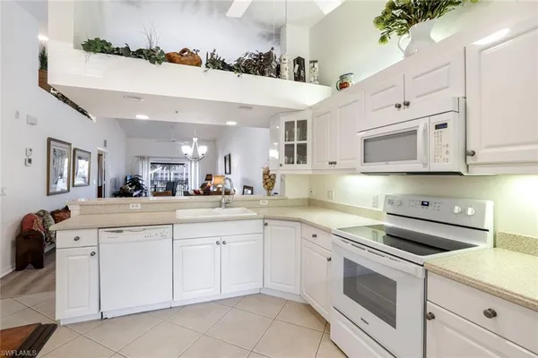 a kitchen with white cabinets stainless steel appliances and sink
