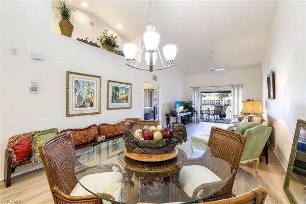 a living room with furniture a chandelier and a mirror