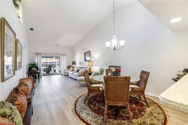 a living room with furniture a chandelier and a dining room