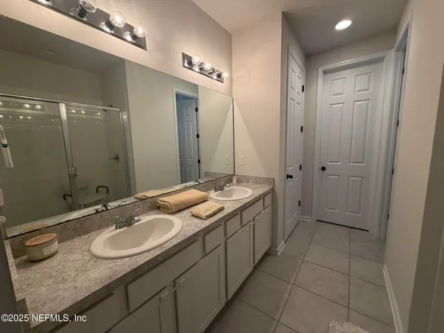 a bathroom with a granite countertop sink a mirror and a bathtub