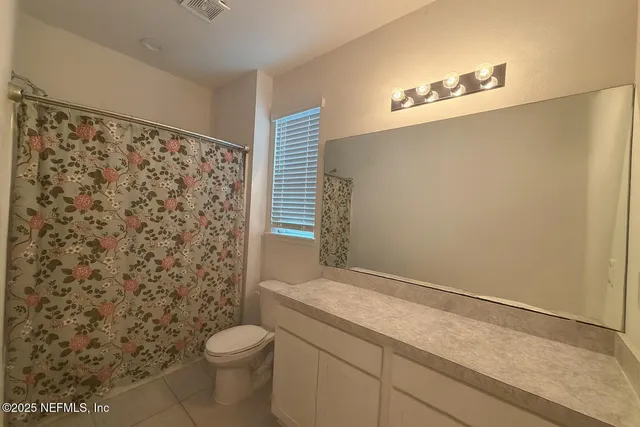 a bathroom with a granite countertop toilet and a shower