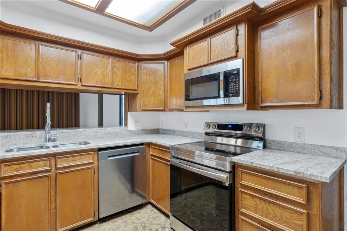 502 Grace Lane Austin, TX 78746 - Photo 13 of 37 a kitchen with granite countertop cabinets stainless steel appliances and a sink