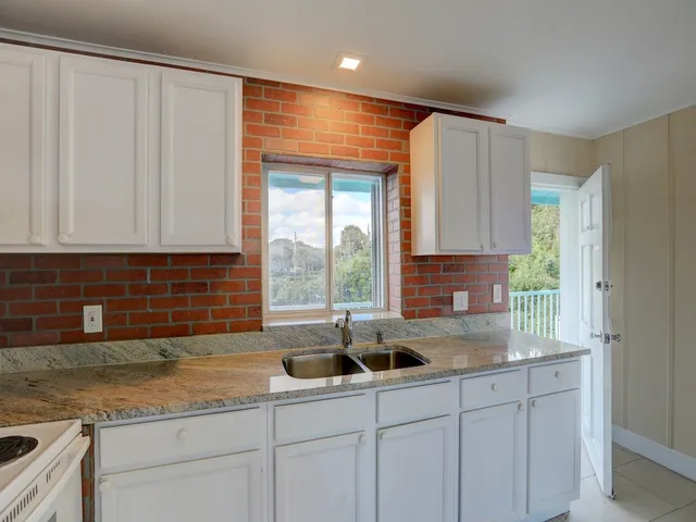 a kitchen with stainless steel appliances granite countertop a sink a refrigerator and a granite counter tops