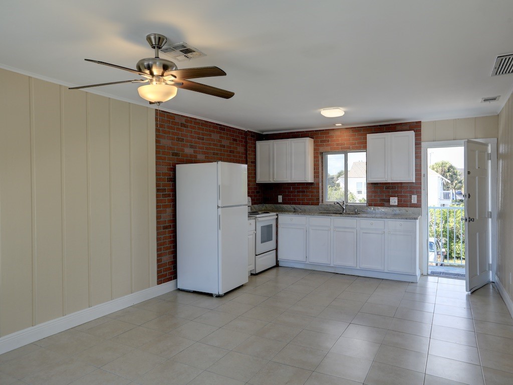1840 Wabasso Beach Road Vero Beach, FL 32963 - Photo 8 of 22 a kitchen with a refrigerator and a sink