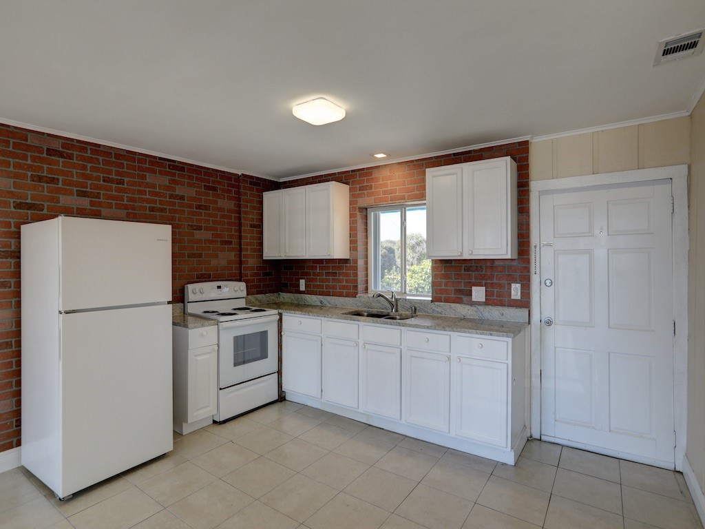 1840 Wabasso Beach Road Vero Beach, FL 32963 - Photo 9 of 22 a kitchen with a refrigerator and a sink
